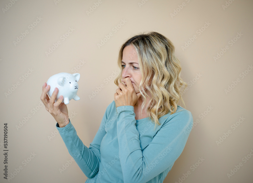 pretty young woman with white piggy bank in front of brown background pretty young woman with white piggy bank in front of brown background