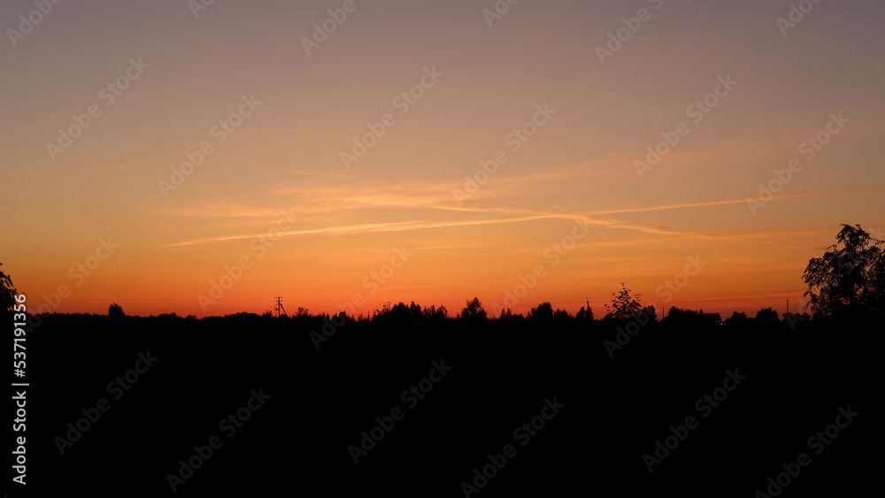 Rural landscape with field at sunset and village in the background. Vologda region Rural landscape with field at sunset and village in the background. Vologda region