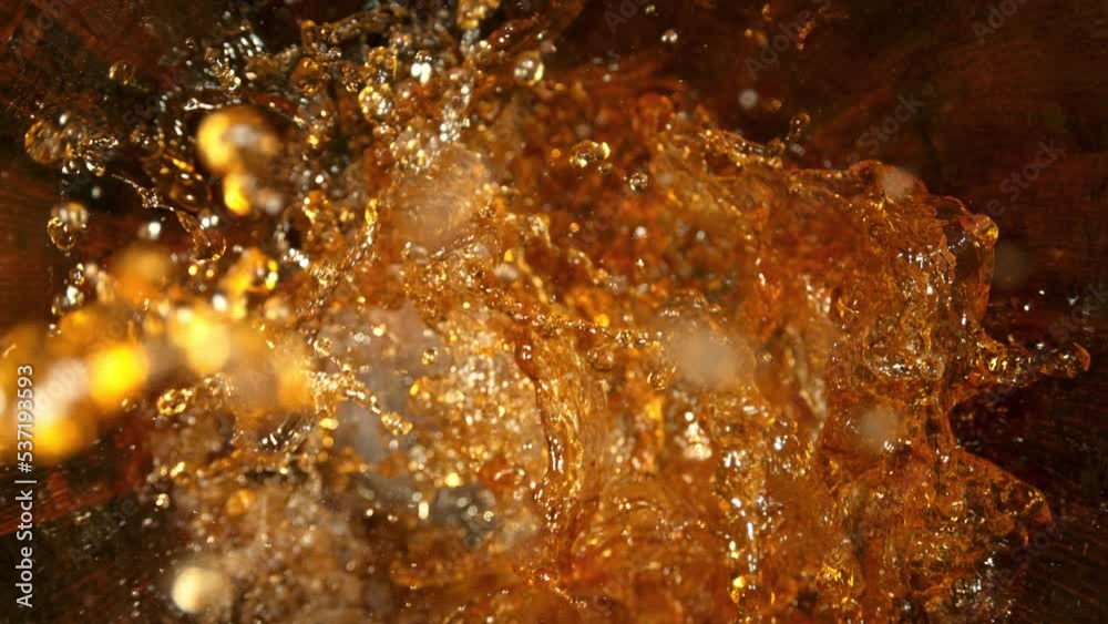 Super Slow Motion Shot of Golden Alcohol Liquid Splashing in Oak Wooden Barrel at 1000fps.