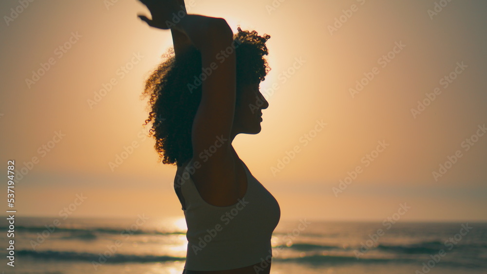 Sporty girl warming body in front sunrise close up. Silhouette athletic woman. Sporty girl warming body in front sunrise close up. Silhouette athletic woman.