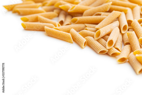 Uncooked whole grain pasta isolated on white background. Raw penne pasta.