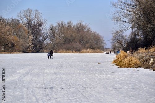 Walk on frozen river on sunny winter day