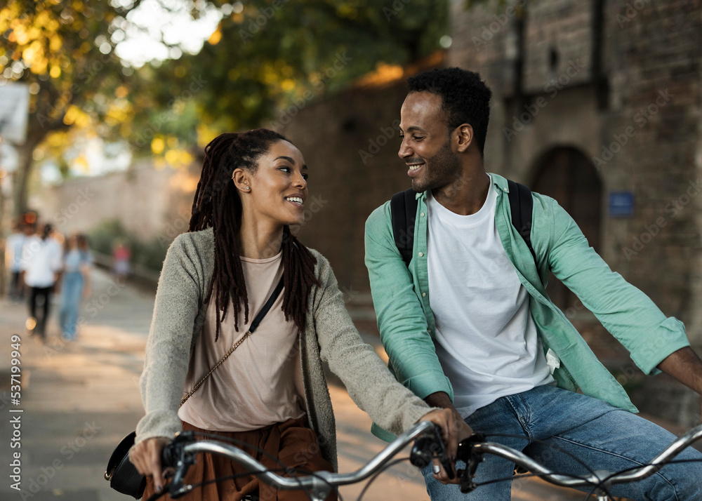 Obraz premium Friends walking with cycle on street during autumn