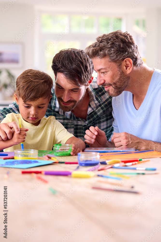 Same Sex Family With Two Dads And Son Painting Picture In Kitchen At Home Together