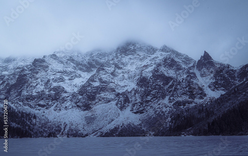 Fototapeta Naklejka Na Ścianę i Meble -  Snowy mountain peaks at Morskie Oko, Poland on a foggy, cold winter afternoon.