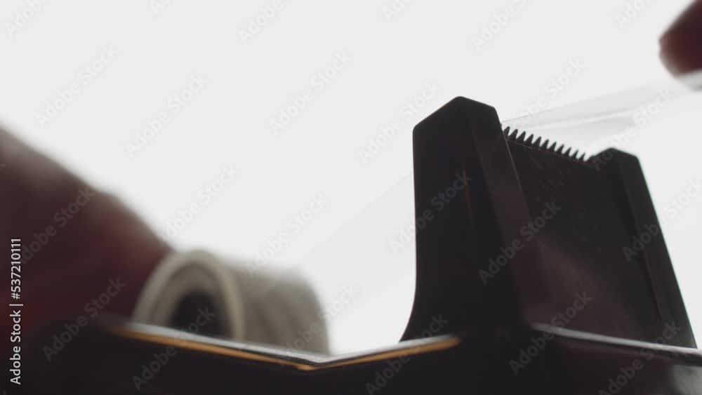 Hand tearing scotch tape from a tape dispenser. Close-up.adhesive,  tape,  closeup,  man,  object,  plastic,  sticky,  roll,  scotch tape,  office,  desk,  dispenser,  business,  work,  scotch,  glue,