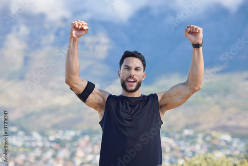 Fitness, winner and yes with a sports man in celebration of a victory outdoor in nature in the mountains. Exercise, training and workout with a young male athlete celebrating his target or goal