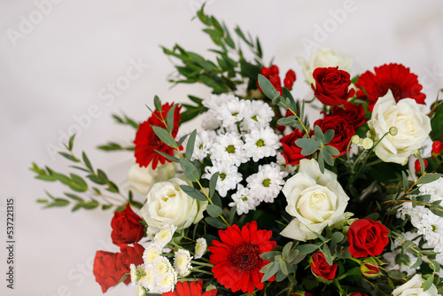 Large bouquet of red and white flowers with green twigs