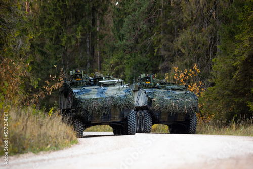 Military training on the battlefield with armored vehicles drives on forest road. Army war concept. photo