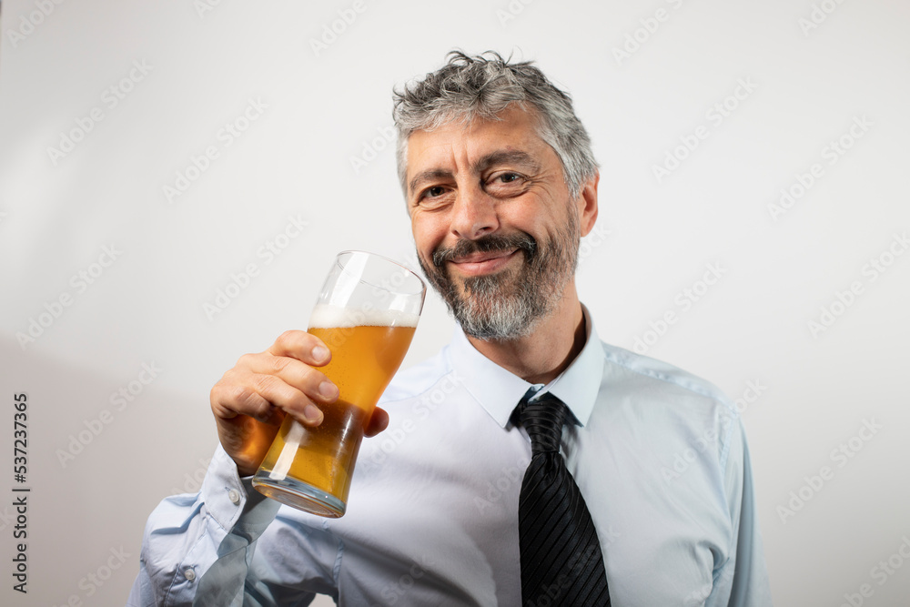 homme de 50 ans, homme d'affaire souriant buvant une bière pour se détendre. Il porte une chemise et une cravate