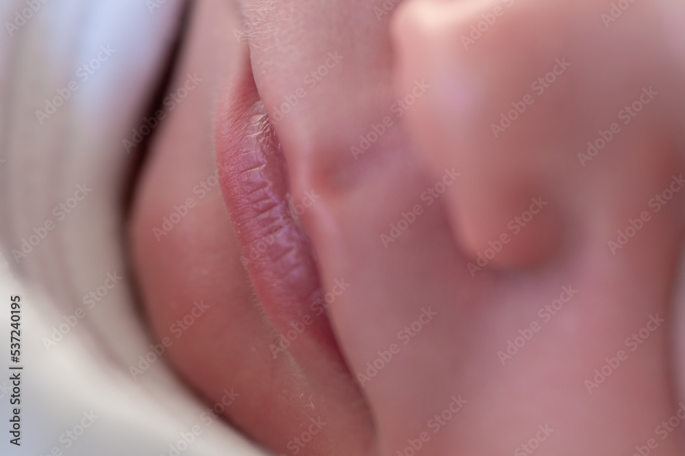 Fototapeta premium closeup of the lips of a tiny newborn baby asleep in his crib. selective focus