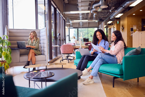 Businesswomen Having Informal Meeting In Breakout Seating Area Of Modern Office photo