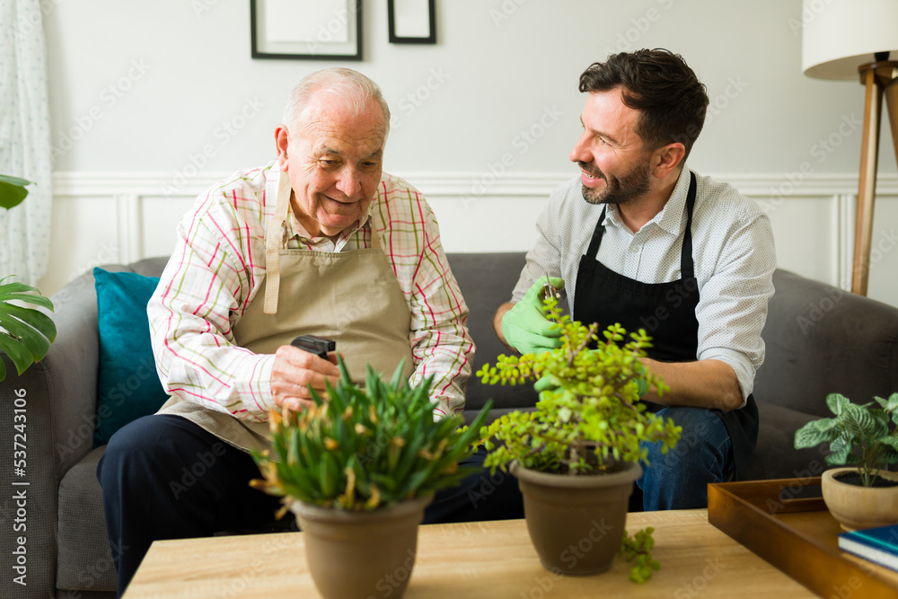 Smiling old father enjoying gardening with his happy son Smiling old father enjoying gardening with his happy son