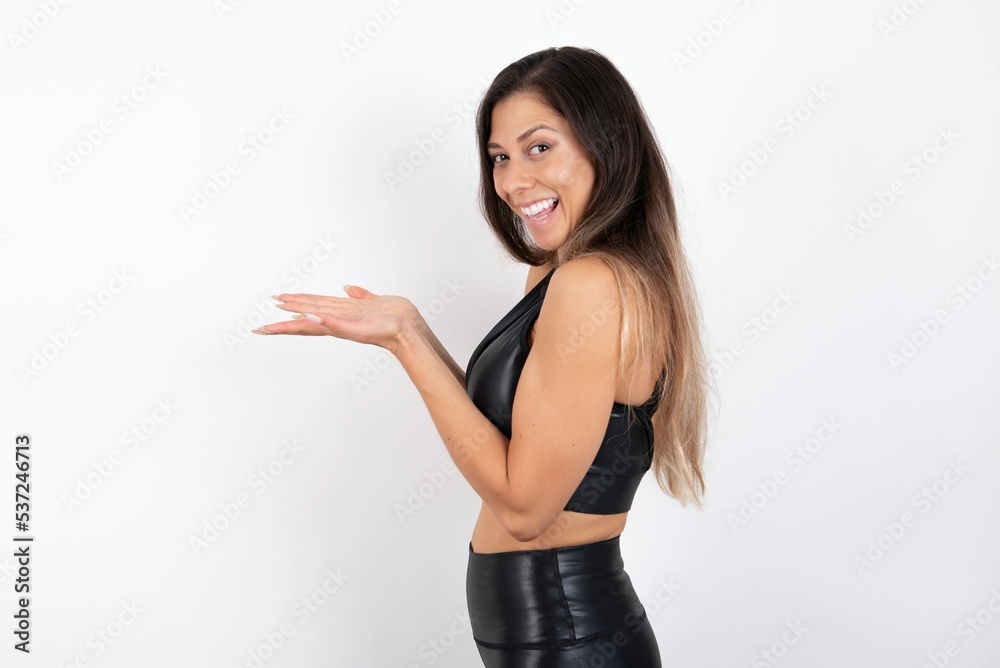young beautiful woman wearing sportswear over white background pointing aside with hands open palms showing copy space, presenting advertisement smiling excited happy young beautiful woman wearing sportswear over white background pointing aside with hands open palms showing copy space, presenting advertisement smiling excited happy