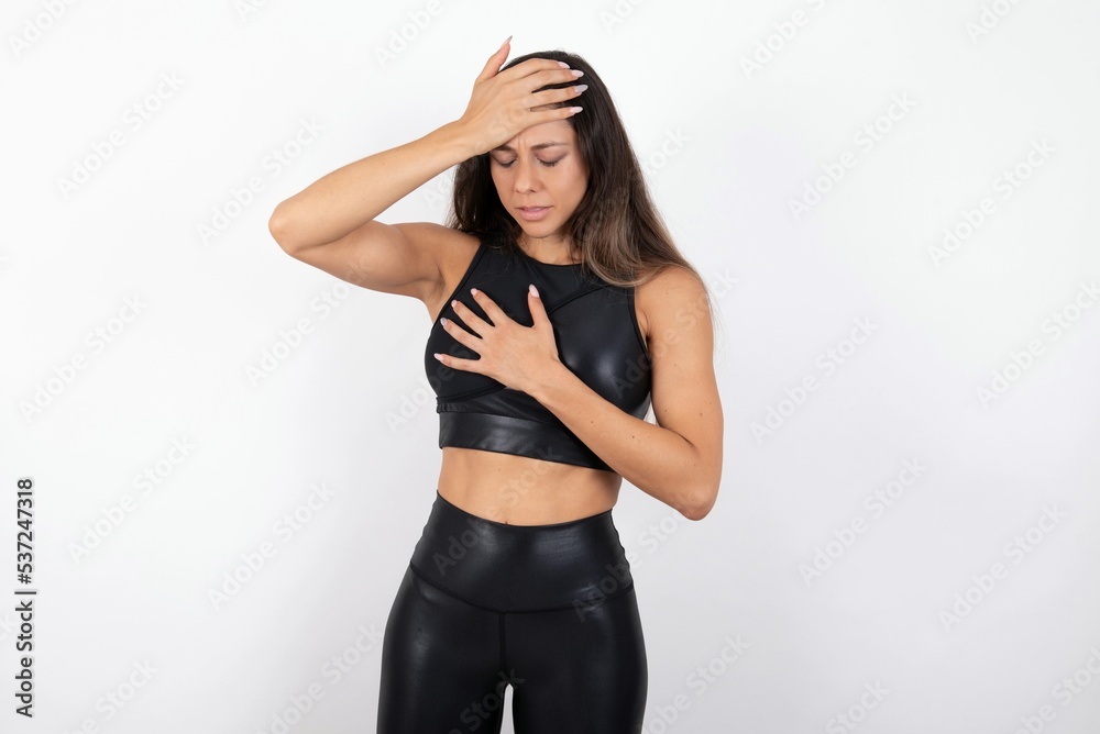 young beautiful woman wearing sportswear over white background Touching forehead for illness and fever, flu and cold, virus sick. young beautiful woman wearing sportswear over white background Touching forehead for illness and fever, flu and cold, virus sick.
