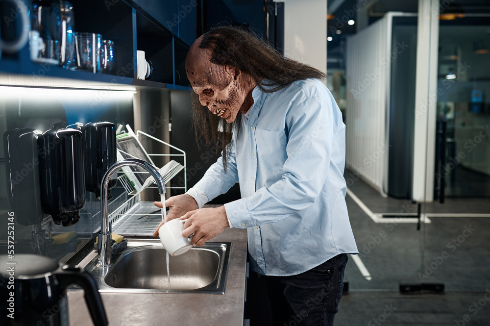 Creepy zombie employee washing cup in sink Creepy zombie employee washing cup in sink