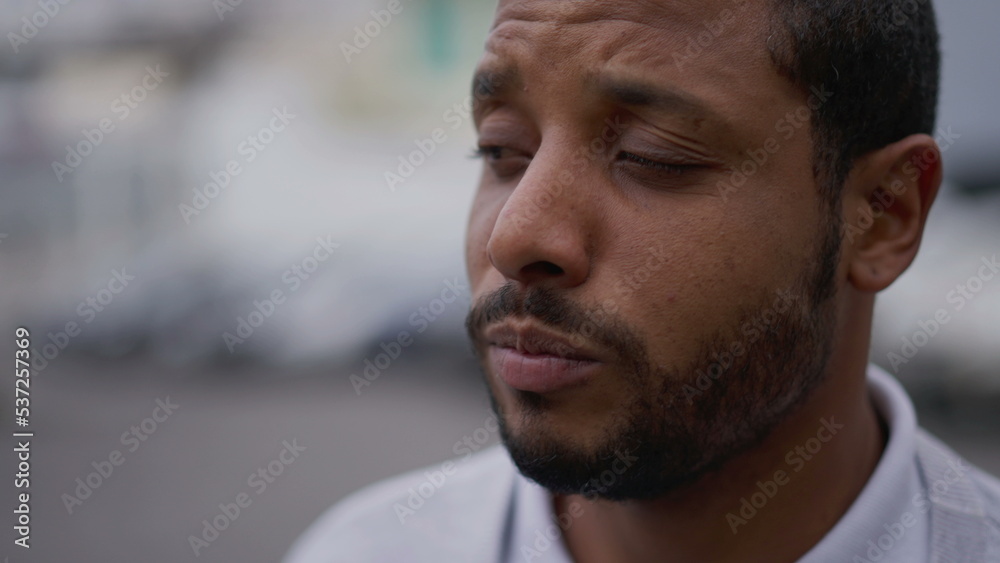 One anxious young African American man in distress closeup face. Portrait of a black person with worried preoccupied emotion One anxious young African American man in distress closeup face. Portrait of a black person with worried preoccupied emotion