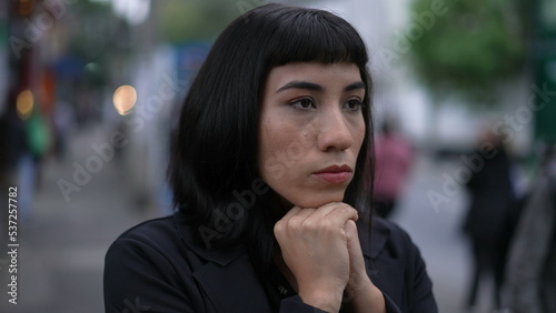 Nervous young woman standing in street feeling anxiety and stress. South American latin adult girl being preoccupied closeup face in urban setting