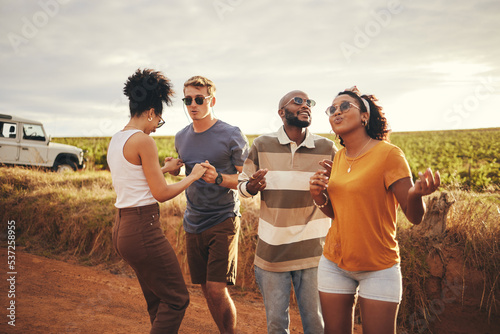 Diversity, friends and dance outdoor on holiday, vacation and relax together on dirt road trip in countryside. Group, students happy and travelling in summer for getaway or fun weekend away as couple photo