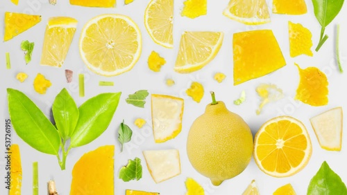 Lemon fruit pieces, slices and leaves being moved upwards isolated on white. Top view. Seamless looping. High quality 4k video.