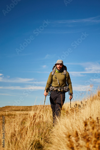 Man walking by mountain trail in Carpathian Mountains, Ukraine. Walking and hiking trails in Borzhava ridge. Rural area of carpathian mountains in autumn © leravalera89