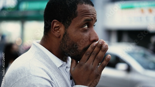 One spiritual young black man praying in street having HOPE and FAITH. African American prays in city urban sidewalk