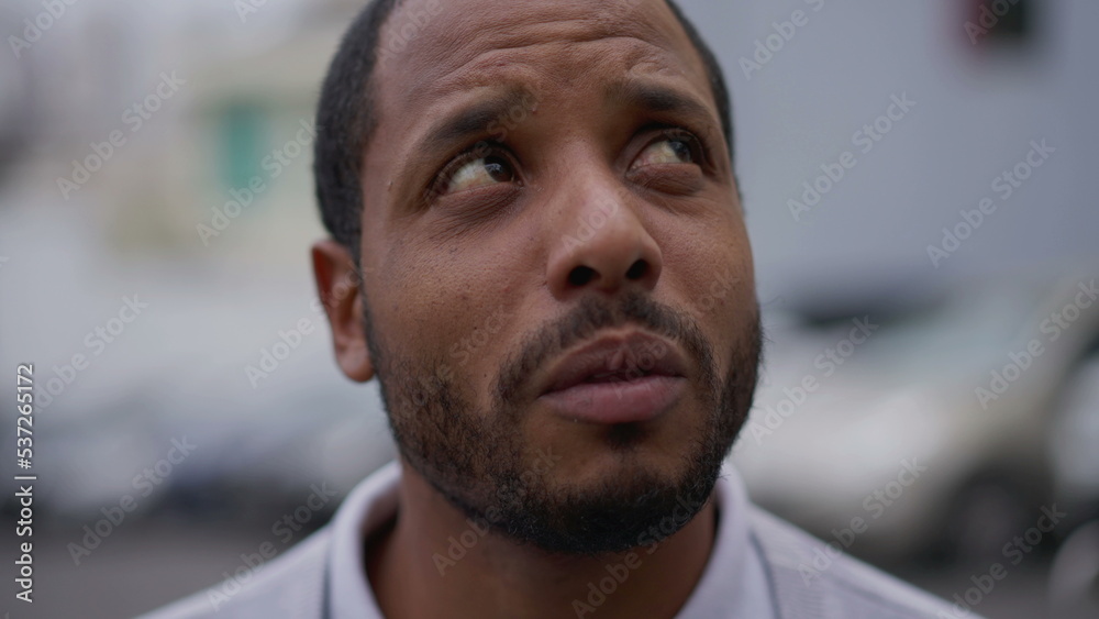 One anxious young African American man in distress closeup face. Portrait of a black person with worried preoccupied emotion One anxious young African American man in distress closeup face. Portrait of a black person with worried preoccupied emotion
