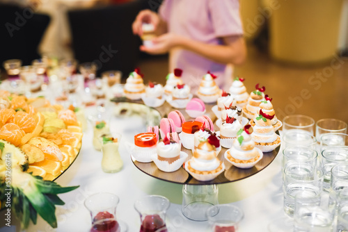 Delicious sweets on wedding candy buffet with desserts, cupcakes