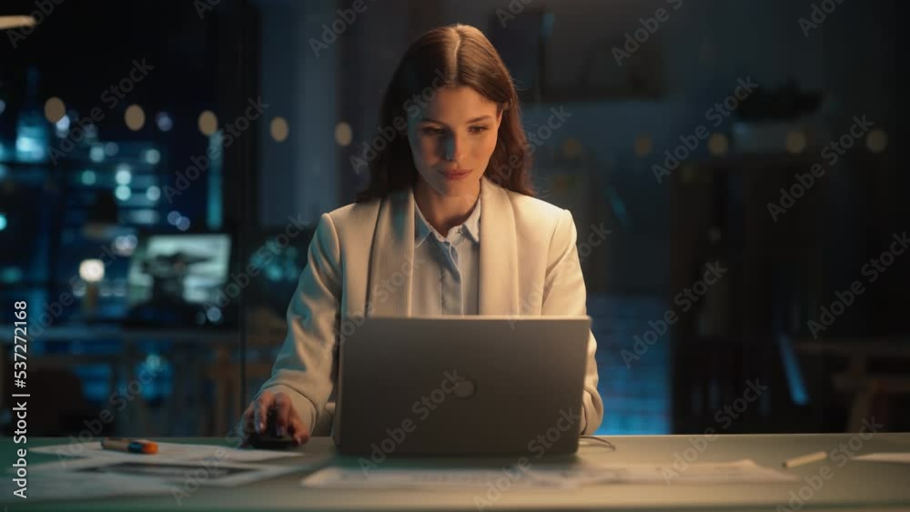 Talented Digital Marketing Specialist Working on Laptop in the Office in the Evening. Young Businesswoman Using Computer in Creative Agency, Checking Emails, Researching Business Analytical Data. Talented Digital Marketing Specialist Working on Laptop in the Office in the Evening. Young Businesswoman Using Computer in Creative Agency, Checking Emails, Researching Business Analytical Data.
