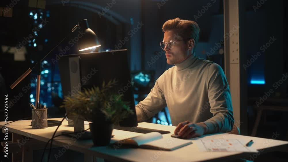 Office at Night: Manager Working Long Hours Alone in Creative Agency, Implementing Business Strategy for Client. Creative Specialist Writing Corporate Project Plan on Desktop Computer.