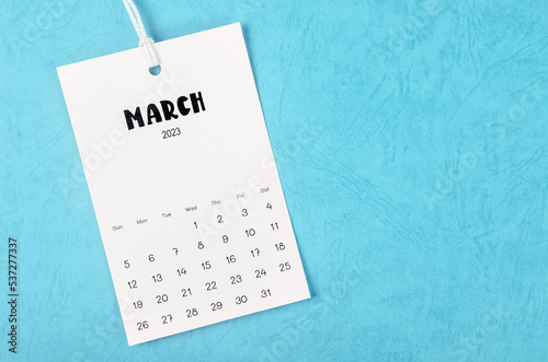 The 2023 March calendar page hanged on white rope  on blue background.
