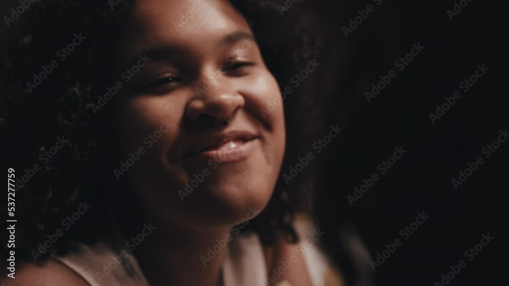 Close-up of young Black lesbian woman and her Caucasian wife sitting at festive table at wedding party flirting with each other Close-up of young Black lesbian woman and her Caucasian wife sitting at festive table at wedding party flirting with each other