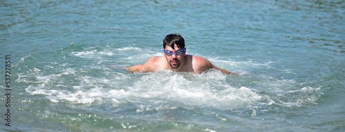 a man in swimming goggles swims in the water
