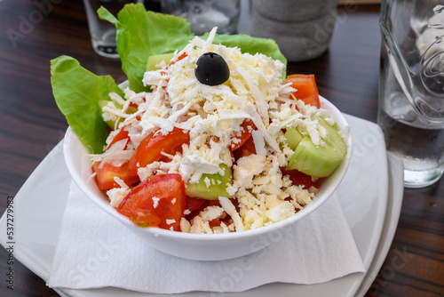 Obraz na płótnie Shopska salad, one of the most popular salads in the menu of the Montenegrin restaurants. Mix of cucumbers, tomatoes, peppers, onions, cheese and olive oil. w salonie