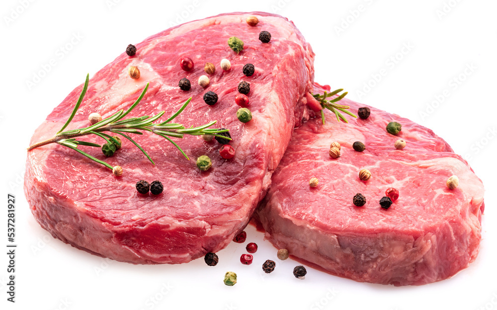 Two fresh ribeye steaks with peppercorn and rosemary isolated on white background. Closeup. Two fresh ribeye steaks with peppercorn and rosemary isolated on white background. Closeup.