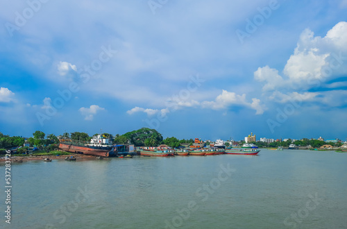 A large tanker ship is being renovated. Ship repairing on the river bank.