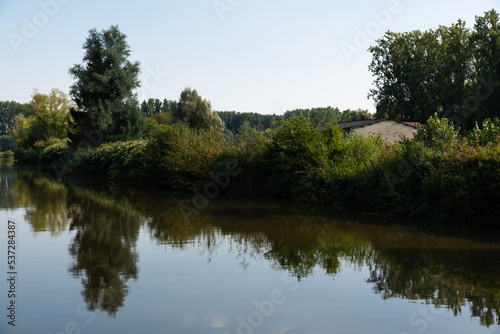 Scenic view over reflecting trees in the water of the River Dender