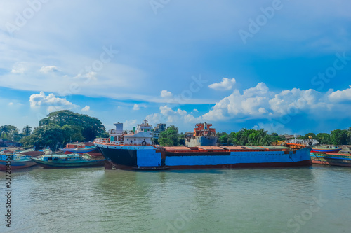 A large tanker ship is being renovated. Ship repairing on the river bank.