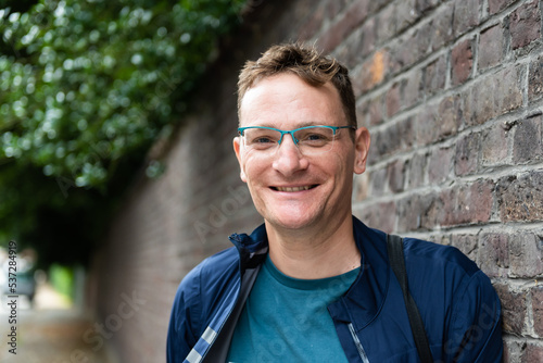 Portrait of an attractive forty year old man standing against a wall