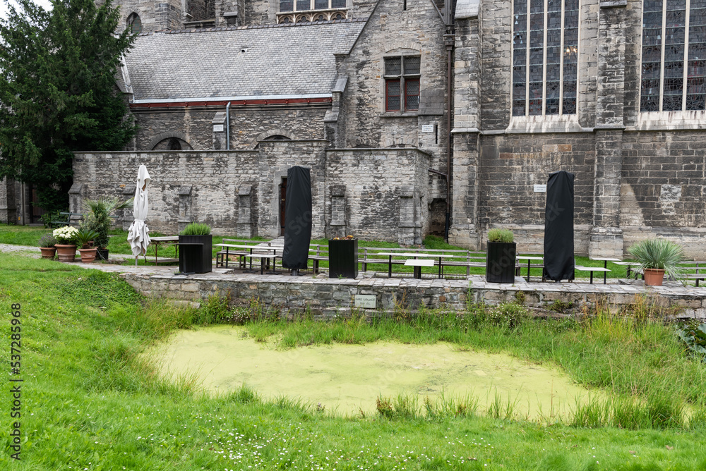 Kortrijk, West Flanders Region - Belgium - Green grass and garden of the catholic church