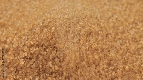 Pouring brown sugar close up. Demerara golden brown sugar photo