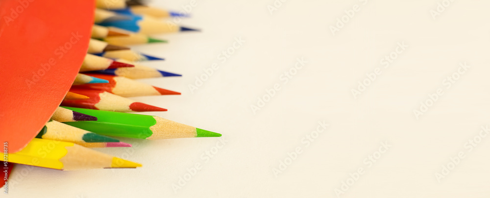 Fototapeta premium Multi-colored pencils in a red box. Back to school. Background with colored wooden pencils and copy space. High quality photo