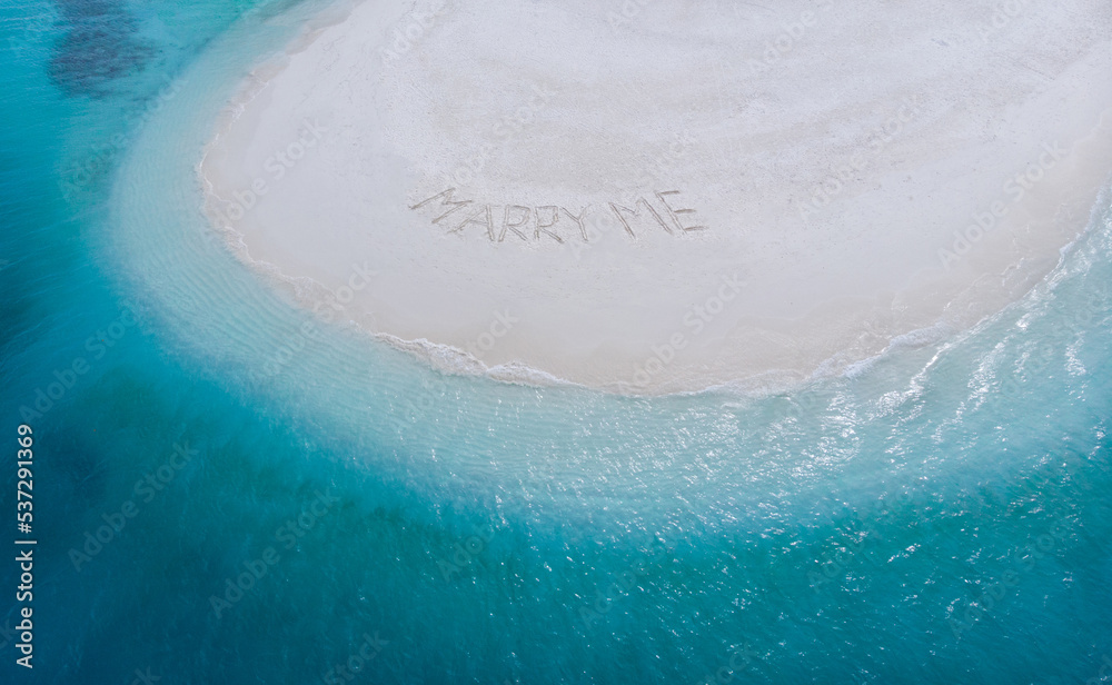 Marry Me Word Written On Sunny Summer Beach Sand. Uninhabited exotic island