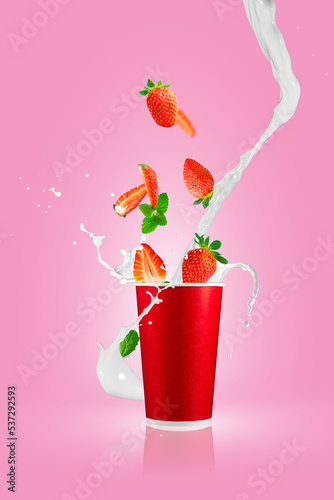Milkshake splash. Milk cocktail with berries. Fresh strawberry berries falling in paper takeaway cup with milk splashes. Strawberry smoothie splash.