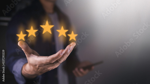 hand of customer or client holding the stars to complete five stars. with copy space. giving a five star rating. Service rating, satisfaction concept