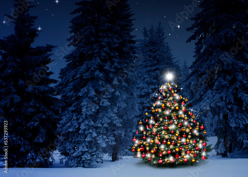 Glänzender Weihnachtsbaum vor einem Blauen Hintergrund im Schnee