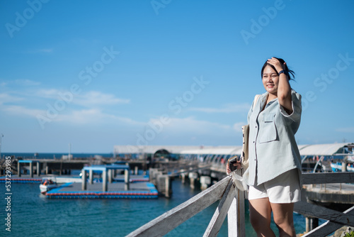 Asian Woman standing happiness with seascape background in Koh larn island pattaya beach, Thailand.