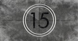 Image of number fifteen in vintage black and white film projector countdown on aged grey background