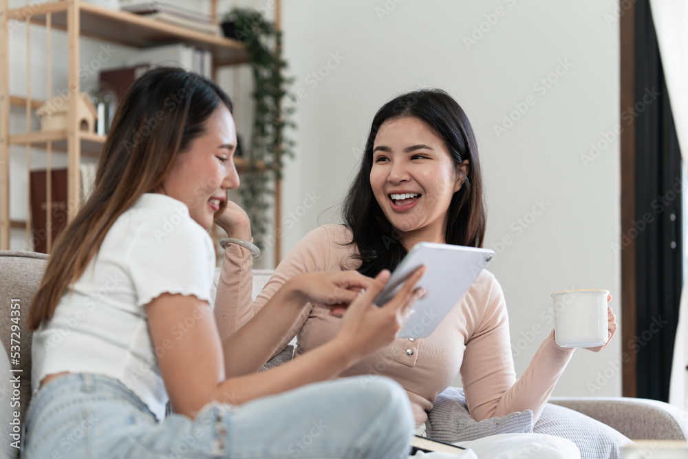 Two Young woman cheering together for sport on TV in cozy living room at home Two Young woman cheering together for sport on TV in cozy living room at home