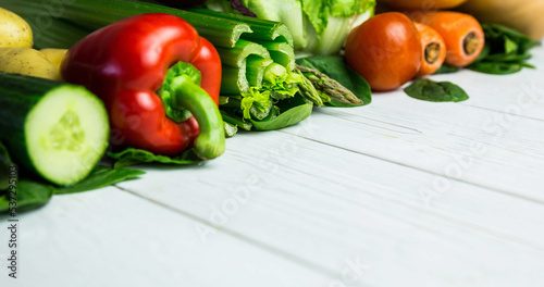 Close-up of fresh various raw vegetables arranged on wooden table, copy space